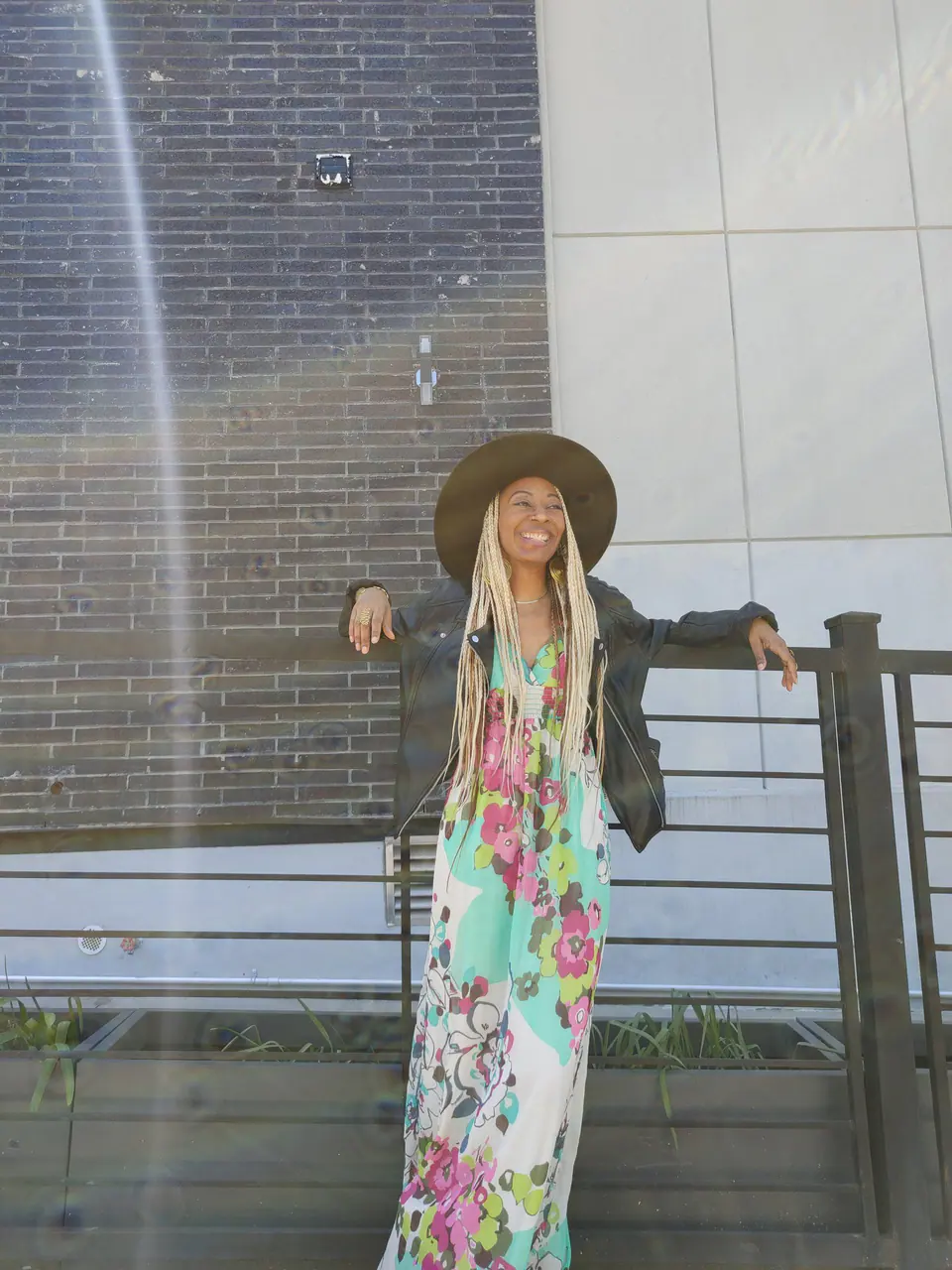 Donna Marie in a floral dress on a balcony
