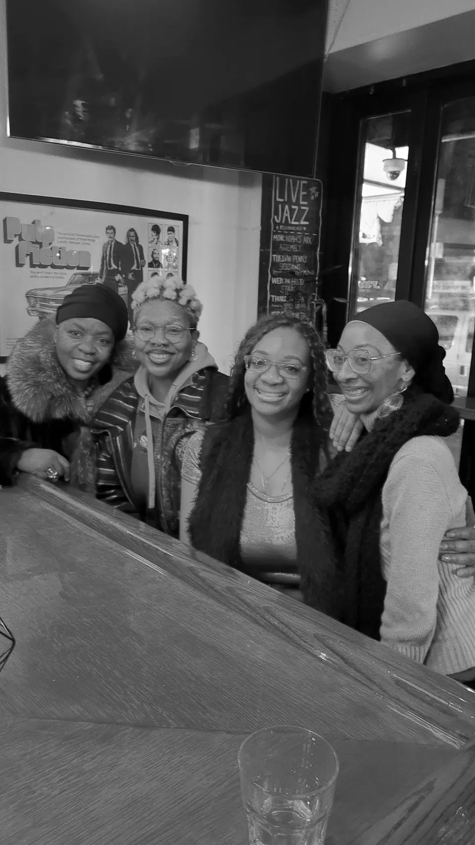 Four women smiling together at a jazz bar