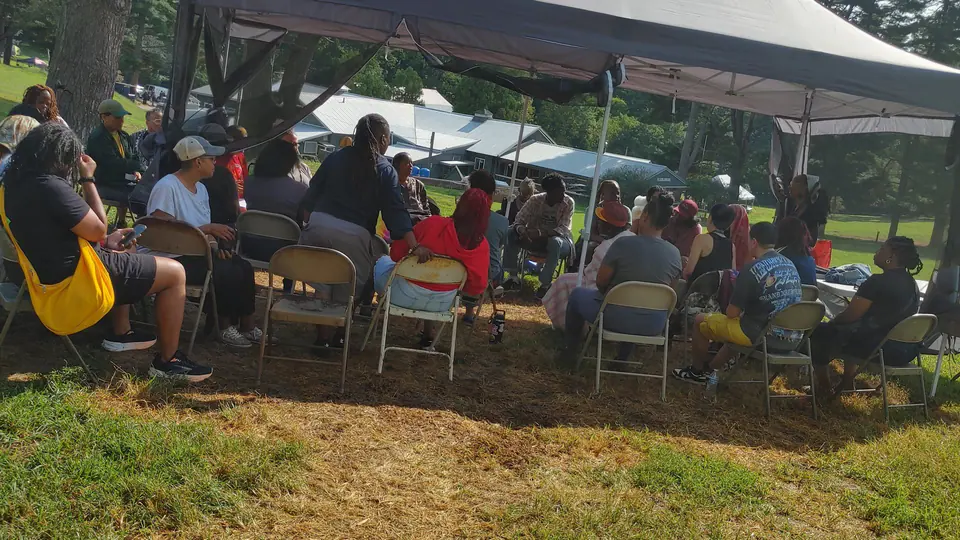 A circle of chairs under a white tent at a workshop