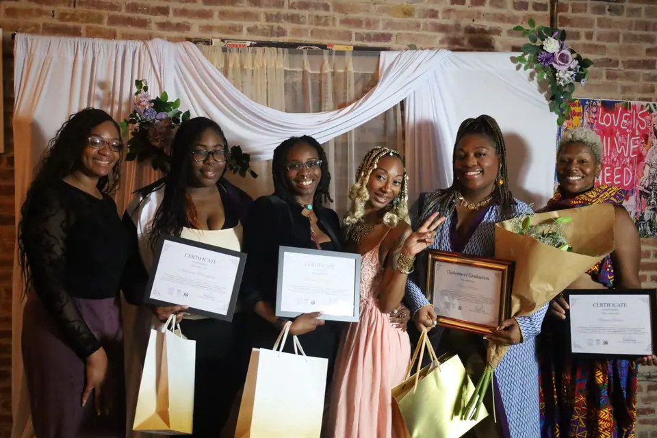 Women smiling with certificates and gift bags