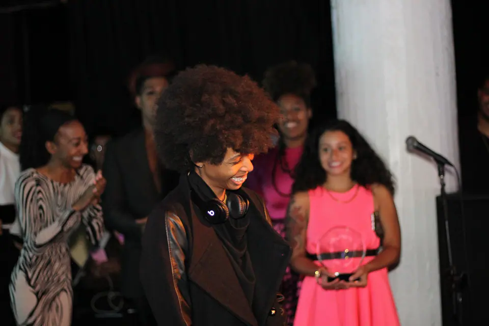 Women on stage laughing together during an event