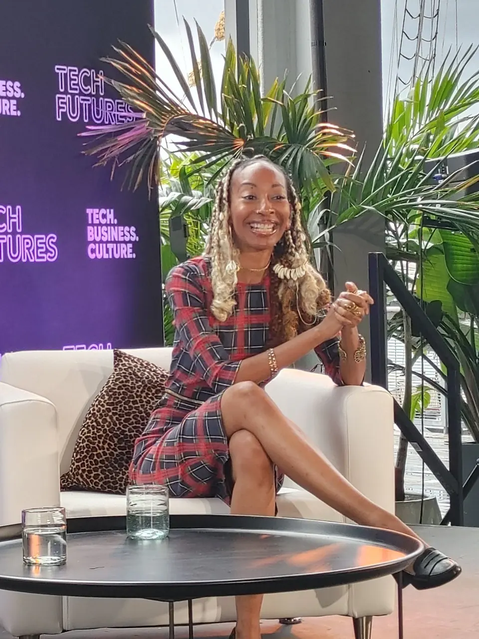 Donna Marie smiling and speaking from a white armchair on a stage